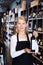 Woman owner of wine store offering bottled wine
