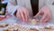 Woman packaging gingerbread cookies with icing for Christmas sitting at table.