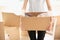 Woman with packed carton box indoors. Moving house concept