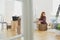 Woman packing books into carton boxes while moving out to a new