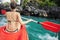 Woman paddles kayak in the lake with turquoise water.