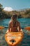 Woman paddling kayak in river through picturesque landscape for a serene outdoor adventure