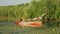 Woman is paddling in kayak on river in summer. Sportive active female is practicing to paddle in canoe on river water. Water sport