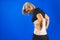 Woman in pain from back injury wearing lumbar brace corset on a blue background, copy space