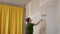 Woman paint wall in her room in grey DIY home repair