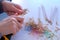 Woman painter artist sharpening orange pencil using sharp knife, hands closeup.