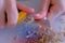 Woman painter artist sharpening orange pencil using sharp knife, hands closeup.