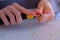 Woman painter artist sharpening pencil using sharp knife, hands closeup.