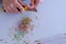 Woman painter artist sharpening yellow pencil using sharp knife, hands closeup.