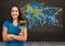 Woman painting a Colorful Map with paint splattered wall background