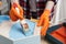 Woman painting honeycomb shaped shelf with brush at wooden table, closeup