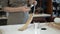 Woman painting a wooden chair leg in a workshop, restoration process