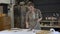 Woman painting a wooden chair leg in a workshop, restoration process