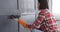 Woman painting wooden wall