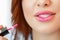 A woman paints her lips with a brush. close-up photo