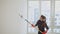 Woman paints the wall in white color while making repairment in newly purchased apartment. Repair and house renovation