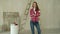 Woman paints walls at home, holds paint brush. Repair, and house renovation concept