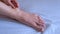 Woman palpates hand leg ankle hygroma in joint, foot closeup view.