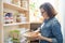 Woman in pantry with bowl of white beans. Storage cabinet in kitchen