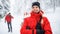 Woman paramedic from mountain rescue service outdoors in winter in forest, looking at camera.