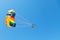 Woman parasailing on parachute in blue sky
