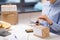 Woman with parcel cutting rope at post office