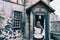 A woman parishioner in a headscarf stands and crosses herself at the door of a retro american church