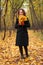 Woman in park in autumn with yellow leaves