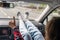 Woman passenger, legs in a jeans and socks on car dashboard while travel on the highway.  Girl showing thumbs up . Freedom