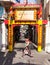 Woman is passing by Buddhist street gate