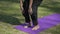 A woman passing from forward fold to equal standing pose in Yoga
