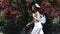 woman passing by red roses on background