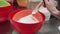 Woman pastry chef hand puts spoon of baking powder into flour in mixing sieve