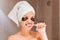 Woman in patches brushing her teeth in the bathroom in the morning. Healty skincare and wellness concept