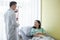 Woman patient listen carefully to doctor advice on hospital bed and doctor filling up with female patient with blood.