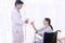 Woman patient sitting on the wheelchair with professional doctor in hospital room ward while showing thumb up giving