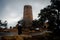 A woman pauses on the path to observe the watch tower in the Grand Canyon on a cold blustery day