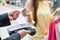 Woman paying credit card with payment terminal and cashier man