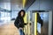 Woman paying in the parking Machine in the airport with a suitcase