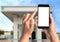 Woman paying for refueling via smartphone at gas station, closeup. Device with empty screen