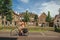 Woman pedaling bicycle in street on the edge of channel on sunny day in Weesp.