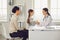 Woman pediatrician doctor talking with mom and baby at clinic office.