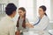 A woman pediatrician makes a setoscope examination to a child girl with mom in a clinic office.