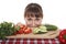 Woman peek out from the table with vegetables