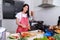 Woman peel carrots with a knife in kitchen room