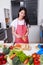 Woman peel carrots with a knife in kitchen room