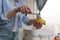 Woman peeling potato into bokashi bin. Female cooking food and composting leftovers. Person using composter container for