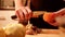 Woman peeling a potato with a knife.