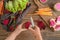 Woman peeling ripe beet over wooden table, top view