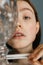 Woman peeps out from behind a glass while sitting